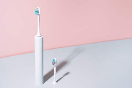 Electric toothbrush with brush head against blue-pink backgroundの写真素材