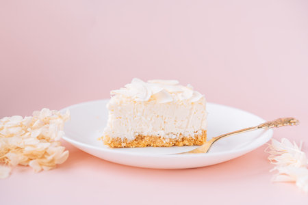 White cheesecake with coconut flavor on plate on pink backgroundの写真素材