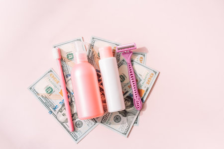 Womens personal care products on dollar bills against pink backgroundの写真素材