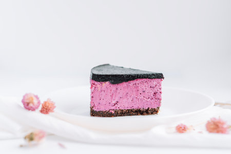 Blueberry cheesecake on plate against white background with clover on napkinの写真素材