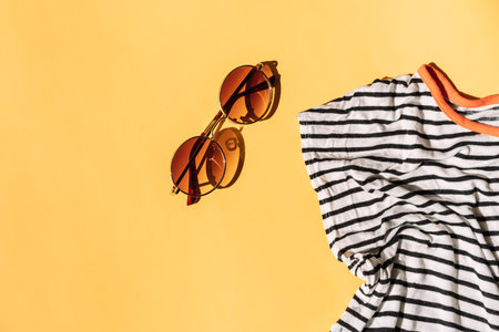 T-shirt blue and white with sunglasses on yellow backgroundの写真素材
