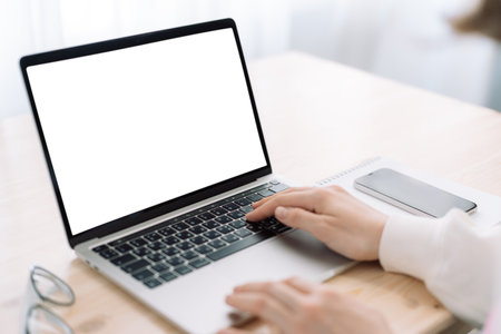 Lady using laptop with white screen on wooden tableの写真素材