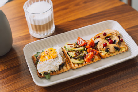 Breakfast toasts with different toppings with a cup of coffeeの写真素材
