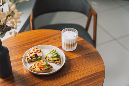 Waffles with seafood and avocado on a white plate with coffee