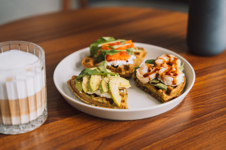 Waffles with seafood and avocado on a white plate with coffeeの写真素材