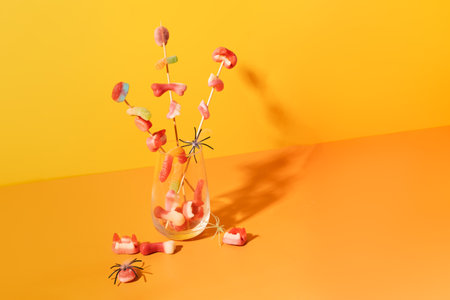 Marmalade on sticks in a glass cup against an orange backgroundの写真素材