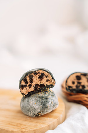 Colored mochi with chocolate filling on a wooden boardの写真素材