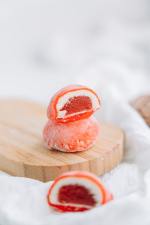 Orange half mochi with berry jelly on a wooden boardの写真素材