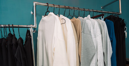 Clothes on hangers hang on the rack in a clothing store