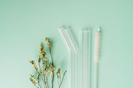 Glass reusable straws with brushes with dried flowers on green backgroundの写真素材