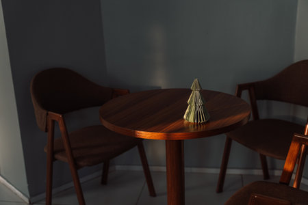Artificial small Christmas tree on a round wooden tableの写真素材