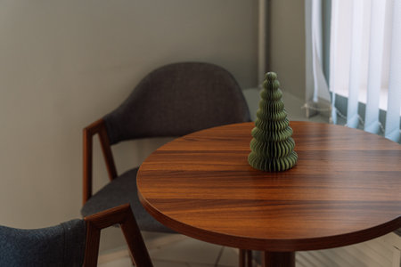 Artificial small Christmas tree on a round wooden tableの写真素材