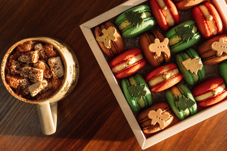 Christmas macarons with chocolate trees and people in a white box with a mug of hot coffeeの写真素材