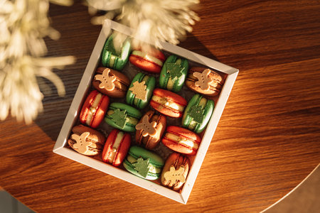 Christmas macarons with chocolate trees and people in a white boxの写真素材