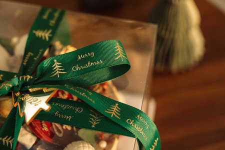 Layer cake with chocolate decorations in transparent packaging with green bow