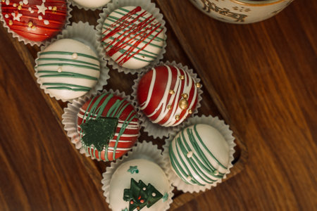 Rum balls of different colors decorated with chocolate in the shape of Christmas tree decorationsの写真素材