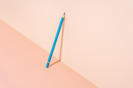 Blue pencil under hard light on a light backgroundの写真素材