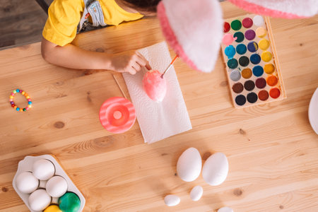 Little girl paints artificial eggs for Easterの写真素材