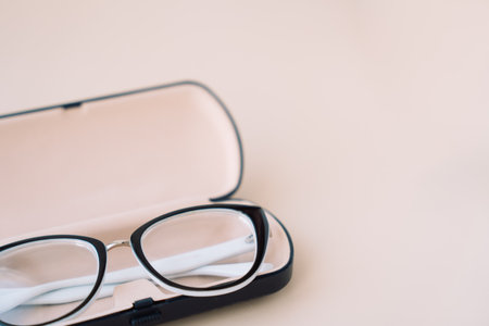 Eyeglasses with black frames in a light case on a light backgroundの写真素材