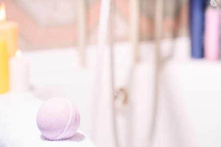 Purple bath bomb on the edge of the bathtubの写真素材