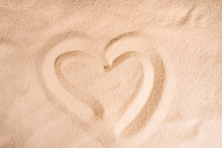 Heart pattern on clean sand under sunlightの写真素材
