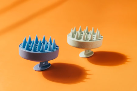 Blue and green massager for the scalp on an orange backgroundの写真素材