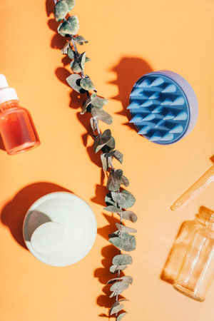 Massagers for scalp and glass jars with serum on a yellow backgroundの写真素材