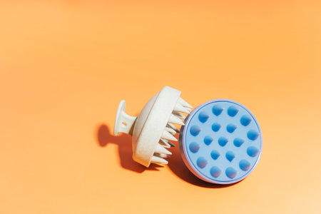 Blue and white massager for the scalp on a yellow backgroundの写真素材