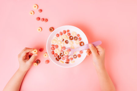 Breakfast of corn rings with milk on pink background