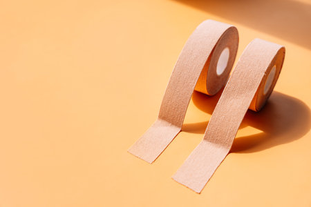 Adhesive tapes for the face in rolls on a yellow background, hard lightの写真素材