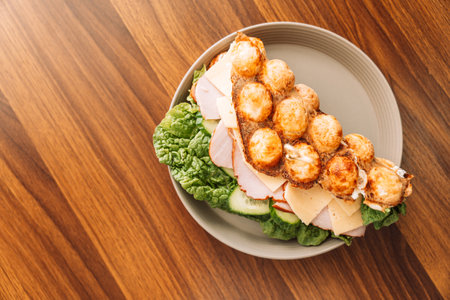 Sandwich bubble waffle with meat, cheese and herbs in a plateの写真素材