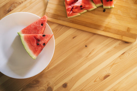 Triangular pieces of watermelon on a wooden cutting boardの写真素材