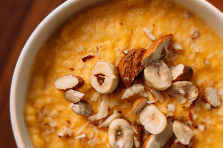 corn porridge with nuts in a white bowl, vertical photo.