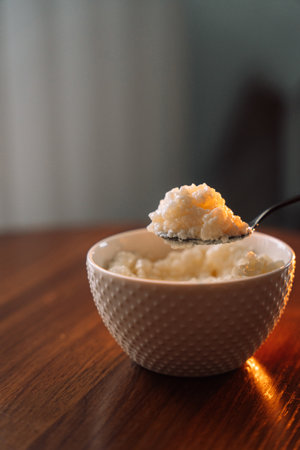 millet porridge with spoon in a white bowl on a dark background.の写真素材