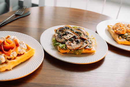 Different types of salty waffles with egg, mushrooms, salmon, mushrooms for breakfast.の写真素材
