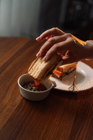Sandwich in hand with tomato sauce, healthy breakfasts