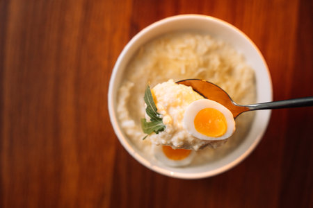 millet porridge with egg in a white bowl on a dark background.