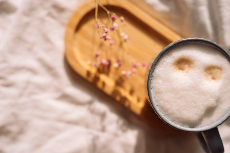 Coffee in bed for breakfast next to pink gypsophila.