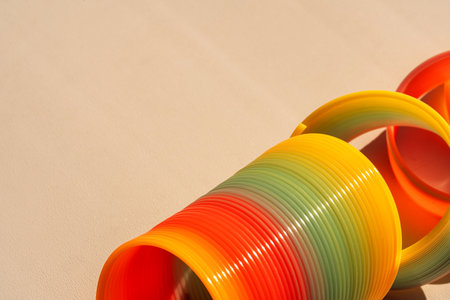 Closeup of rainbow spring toy and rings in soft lightの写真素材