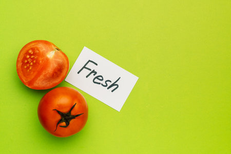Red tomato with note Fresh on green background, organic food conceptの写真素材