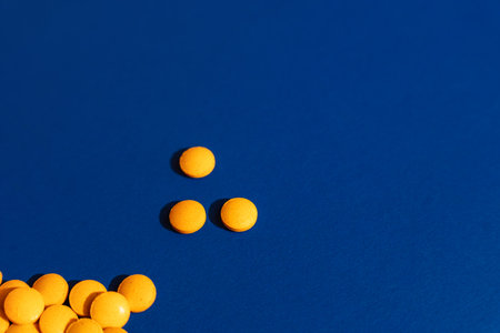 Orange tablets on blue background, minimal layout