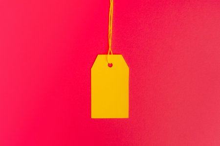 Centered yellow price tag on pink background with copy space