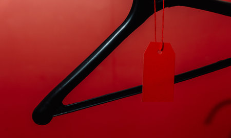 Black hanger with red price tag on red background