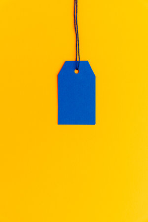 Blue price tag on yellow background minimal top viewの写真素材