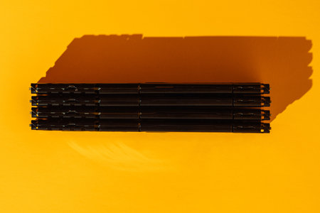 Four black RAM modules stacked horizontally on yellow background