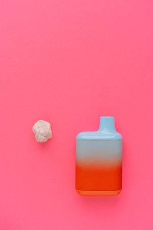 Disposable vape device with gum piece on pink background, minimal concept
