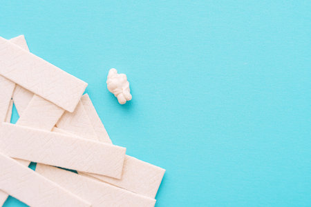 Chewing gum sticks scattered on turquoise background, copy space