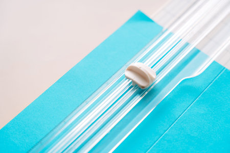 Angled view of paper trimmer and blue paper sheet, DIY scrapbooking tools on pastel desk