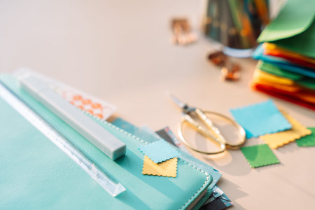 Close up of planner supplies with scissors and colorful paper squares on pastel desk, minimal creative workspaceの写真素材