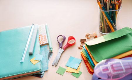 Stationery set with notebook, scissors, pencils, stickers and colorful paper squares, scrapbooking...